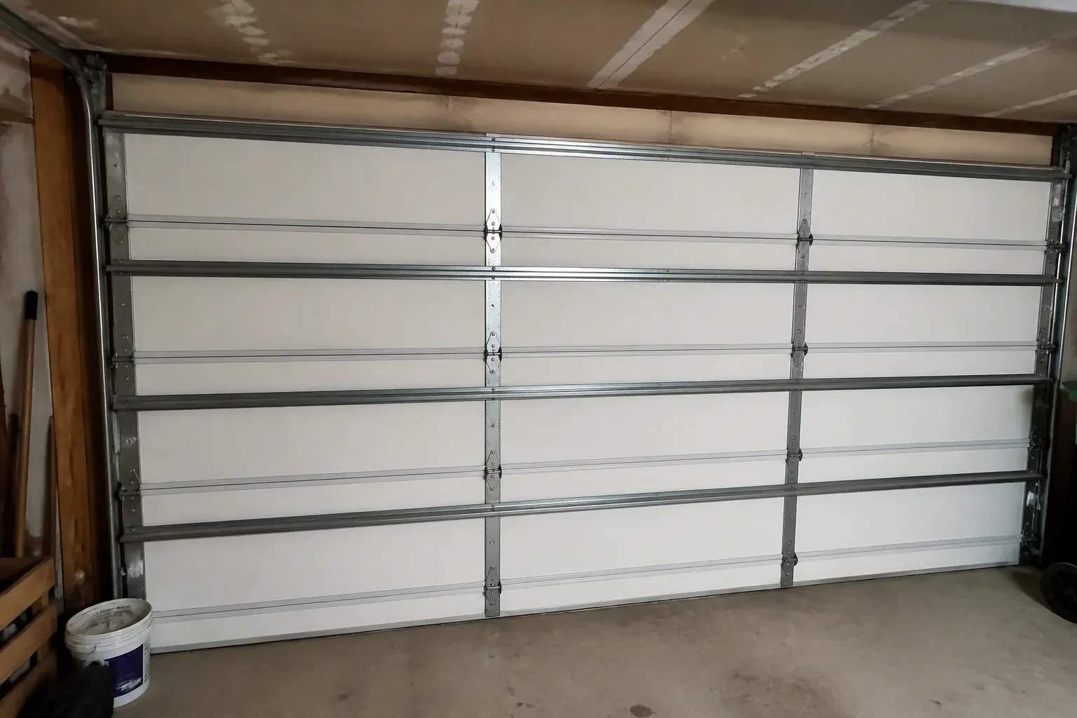 Interior of a closed sectional door with horizontal metal reinforcement struts. — Wind-Rated Garage Door Replacement, Waterloo